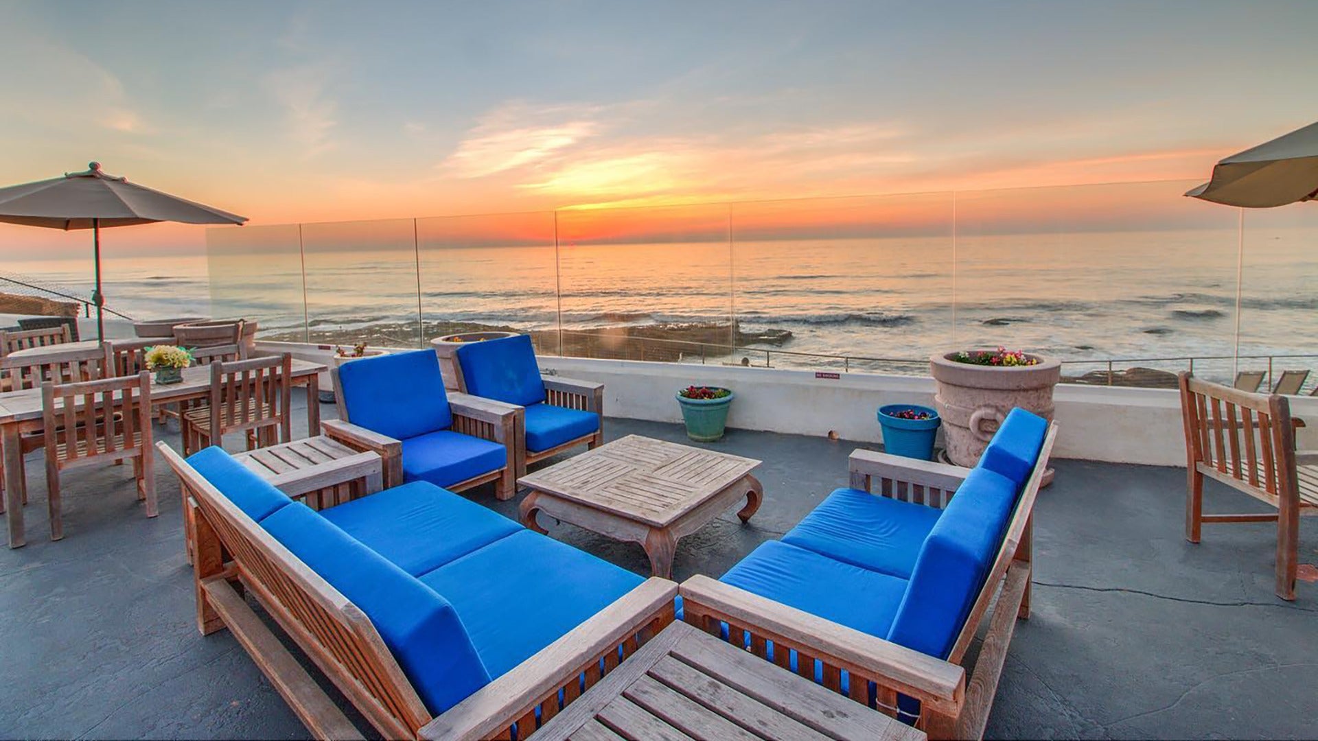 seating area with umbrellas overlooking ocean and sunset